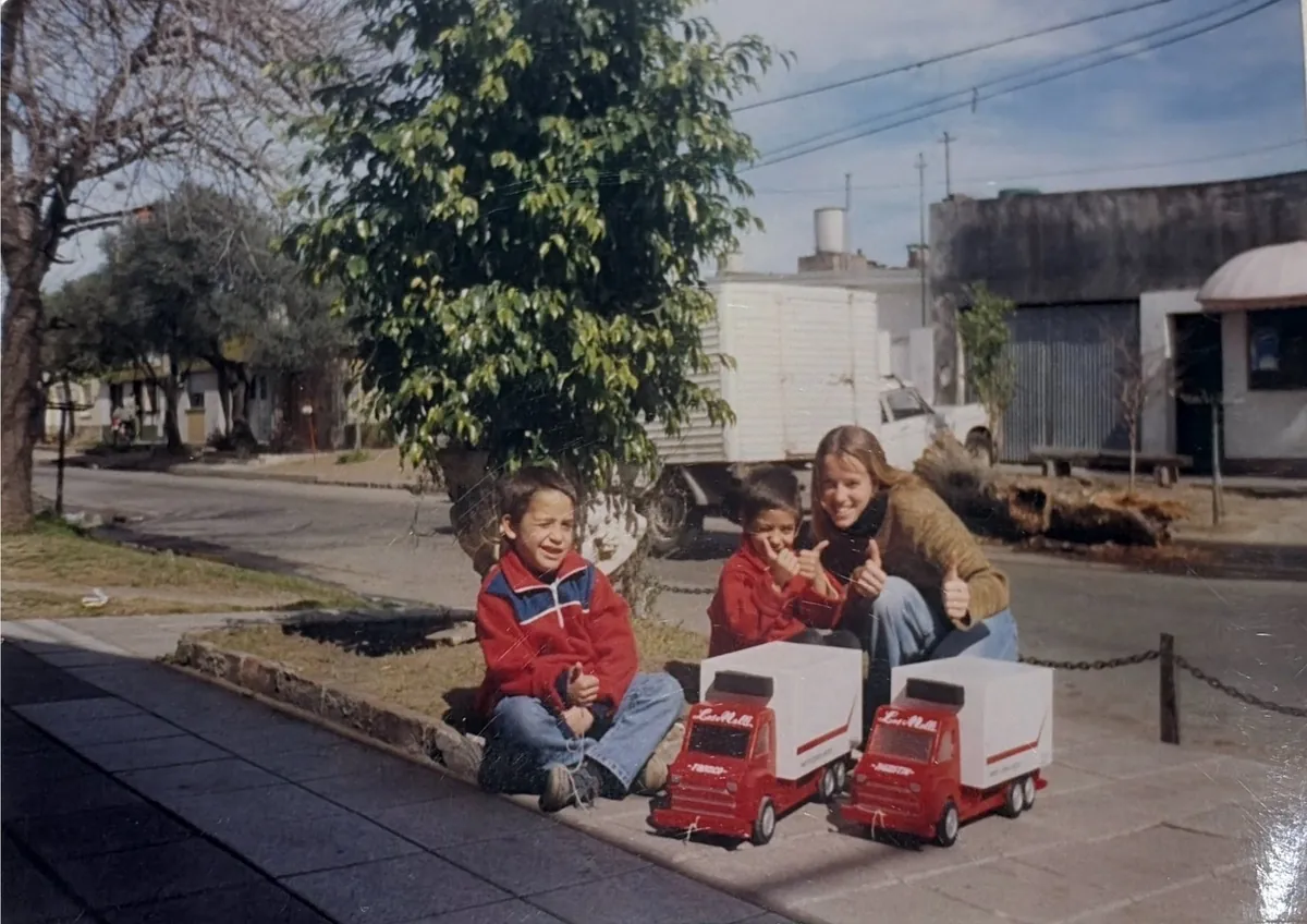 Los nietos mellizos de la familia jugando con dos camiones de juguete iguales a los de la flota